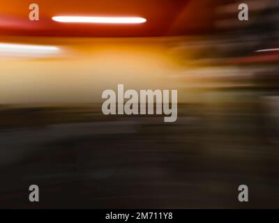 Verwischen Sie das unscharfe Bild des Gangs im Supermarkt mit leichtem Bokeh. Verschwommenes abstraktes Bild des Hintergrunds eines Einkaufszentrums. Stockfoto