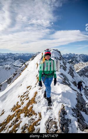 Glücklicher Wanderer, Kletterer auf dem Gipfel, Wandern zur Ammergauer Hochplatte in den Ammergaualpen im Winter, schneebedeckte Berge, Bayern, Deutschland Stockfoto