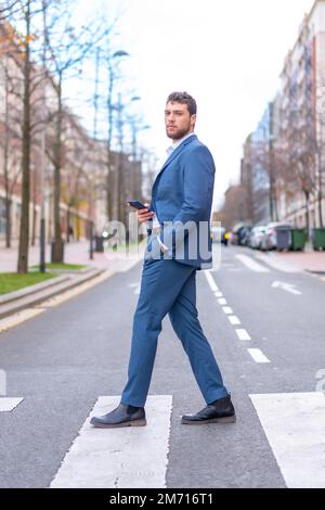 Geschäftsmann oder Finanzmann, der einen Zebraübergang in der Nähe des Büros überquert, Jungunternehmer-Konzept Stockfoto