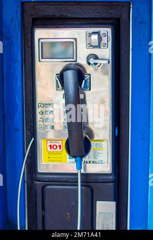 Öffentliches Telefon mit blauer Abdeckung Stockfoto