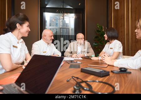 Ärzteteam diskutiert Arbeitsprobleme in einer freundlichen Atmosphäre Stockfoto