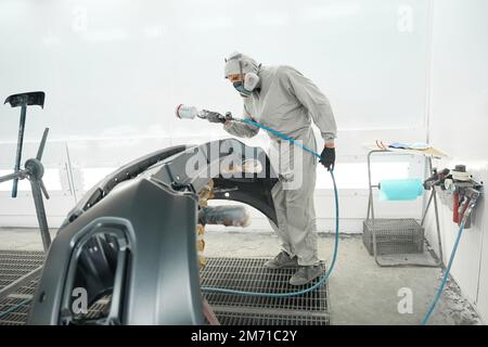 Männchen, der für Autoteile Farbrestaurationen durchführt Stockfoto