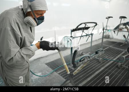 Männchen, der für Autoteile Farbrestaurationen durchführt Stockfoto