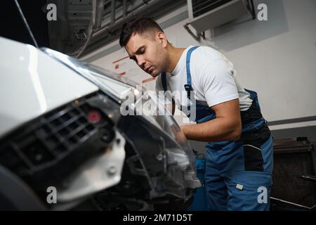 Techniker, der die technische Inspektion des Fahrzeugs in der Reifenwerkstatt durchführt Stockfoto