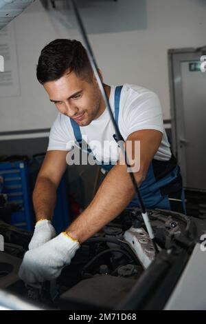 Porträt eines jungen Mechanikers, der Autoreparaturen durchführt Stockfoto