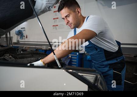 Porträt eines jungen Mannes bei Autoreparaturen Stockfoto