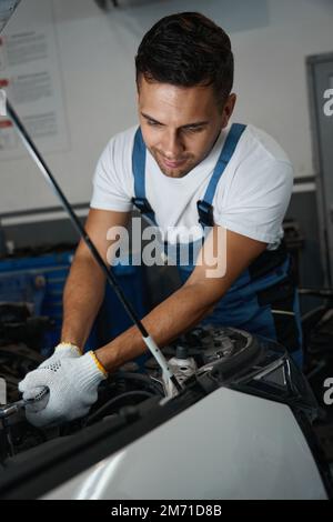 Porträt eines jungen Mechanikers, der Autoreparaturen durchführt Stockfoto