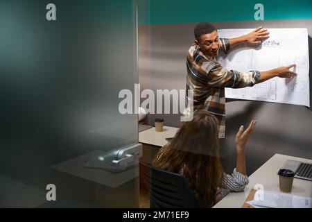 Zwei Kollegen erörtern das Zeichnen im Besprechungsraum Stockfoto