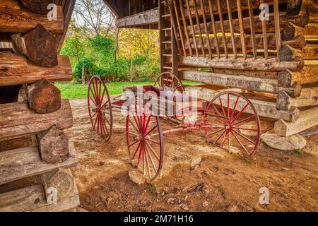 Ein farbenfrohes Bild eines antiken Pionierwagens, der inmitten der berühmten Auslegerscheune Tipton Place im Abschnitt Cades Cove des Great SM ruht Stockfoto