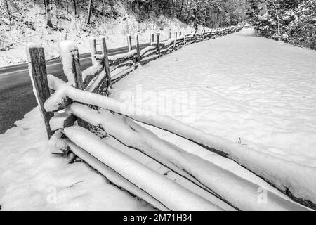 Der Great Smoky Mountains-Nationalpark wurde an einem Morgen im März von einem Spätwinter mit einer letzten Schneedecke bedeckt, die diesen alten Holzzaun bedeckte Stockfoto