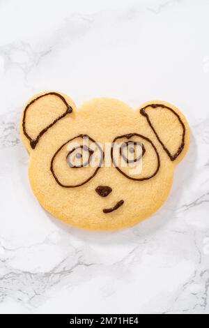 Panda-förmige Shortbread-Kekse mit Schokoladenglasur Stockfoto