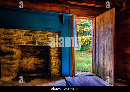 Die Herbstblätter teilen ihre Schönheit mit jedem, der von dieser Cades Cove Hütte in den Smoky Mountains, der Carter Shields Hütte, aus schaut. Eine Sache noch Stockfoto