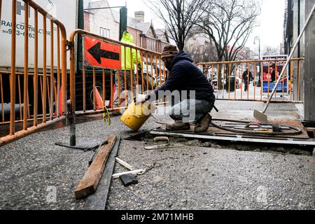 New York, USA. 6. Januar 2023. Ein Bauarbeiter repariert den Bürgersteig in New York, USA, am 6. Januar 2023. US-Firmen haben 223.000 neue Arbeitsplätze geschaffen, und die Arbeitslosenquote sank im Dezember 2022 auf 3,5 Prozent, laut Daten aus den USA Arbeitsministerium am Freitag veröffentlicht. Kredit: Ziyu Julian Zhu/Xinhua/Alamy Live News Stockfoto