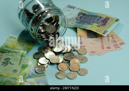 Glasgläser mit Münzen, isoliertes Sparkonzept. Rumänische Banknoten, Wirtschafts- und Finanzkonzept, steigende Preise, Wert des rumänischen Leu Stockfoto