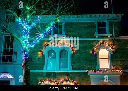 Weihnachtsdekorationen an einem Haus und beleuchteter Baum in Saffron Walden Stockfoto