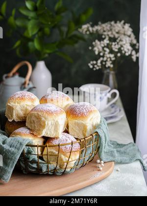 Hausgemachte Milch und Käsesahne in einem Korb mit einem Tuch neben einem Fenster Stockfoto