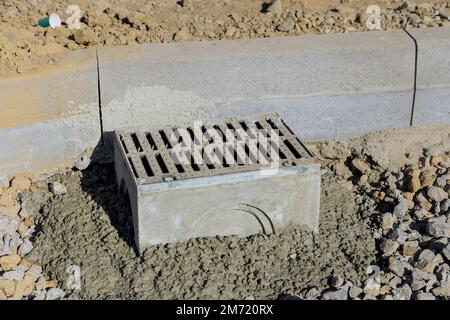 Bau einer Straße auf gut vorbereitetem Betonboden während der Verlegung eines Regenwasserabflusssystems, das installiert wird Stockfoto