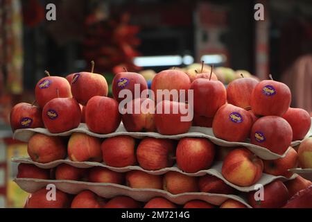 Ein roter fauler Apfel liegt unter reifen, gesunden gelben Äpfeln in Vollbild. Stockfoto