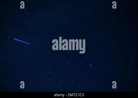 Sternmeteoritenkomet im Hintergrund eines blauen dunklen Sternenhimmels mit Galaxien und Nebeln Stockfoto