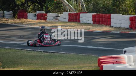 Queretaro, Queretaro, 11 18 22, Junge mit Helm und Rennuniform, fährt Gokart auf der Kartbahn, sommerlicher Adrenalinsport Stockfoto