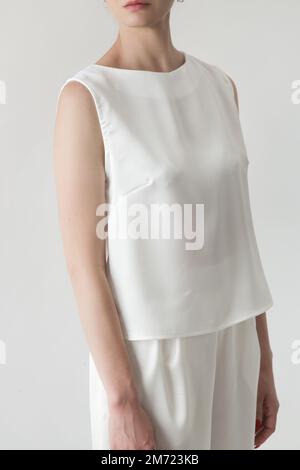 Studiofoto eines weiblichen Models mit weißer, ärmelloser Bluse aus Seide Stockfoto