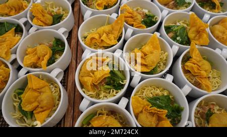 Nudelgrünes Gemüse und gebratene Knödel in einer Schüssel, die in Surabaya, Indonesien, normalerweise als Hähnchennudeln bezeichnet wird Stockfoto