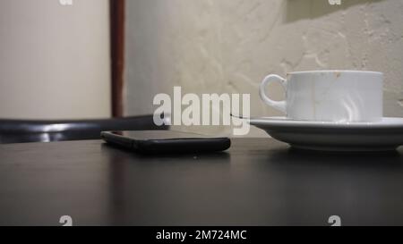 Eine Tasse Kaffee nach Lifestyle-Konzept auf Tisch und Sitzbank im Café-Restaurant Stockfoto