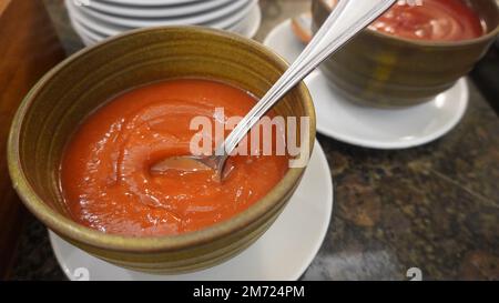 Rote Chili-Tomatensoße in Schüssel mit Löffel Stockfoto