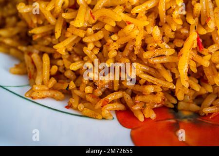 nigerianischer Jollof Reis serviert mit Plantain Stockfoto