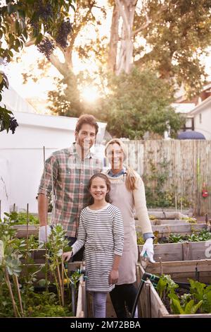 Wir sind eine organische Familie. Porträt einer glücklichen Familie, die zusammen im Garten gärtnert. Stockfoto