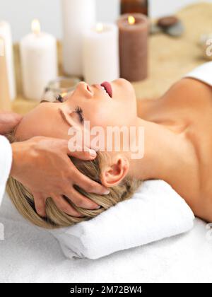 Sie lässt ihren Stress verschwinden. Eine schöne junge Frau, die eine Massage in einem Spa bekommt. Stockfoto