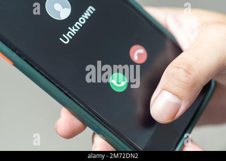 Mann mit Mobiltelefonanruf von unbekannter Nummer. Betrug, Betrug oder Phishing mit Smartphone-Konzept. Mann, der einen eingehenden Anruf entgegennimmt. Stockfoto