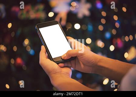 Männerhände, die nachts in der Stadt ein Smartphone benutzen, mit Hintergrund-Bokeh. Leeres Modell des weißen Bildschirms. Stockfoto