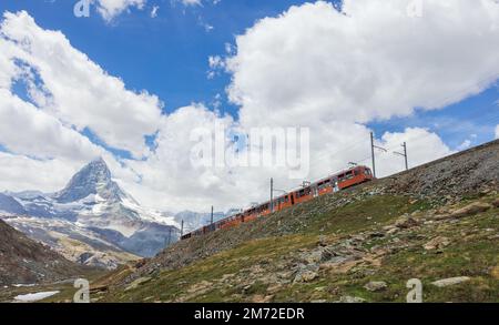 Roter Zug auf dem Hintergrund des Matterhorns in den Schweizer Alpen Stockfoto