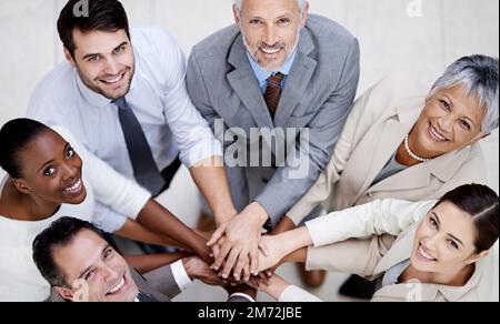Der Erfolg ist in greifbarer Nähe. Eine Gruppe von Geschäftsleuten, die ihre Hände in einer Einheit zusammenlegen. Stockfoto