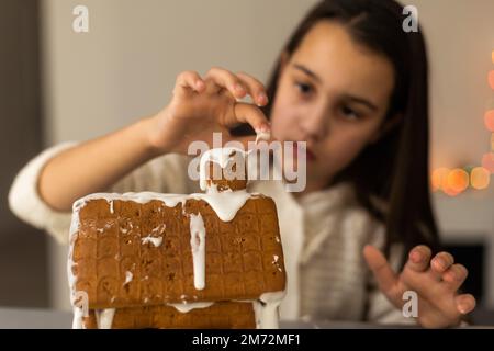 Ein junges Mädchen, das zu Hause Lebkekse macht. Stockfoto