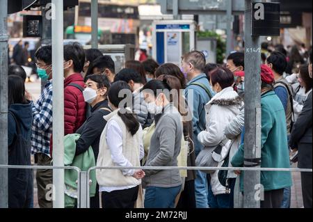 Hongkong, China. 07. Januar 2023. Fußgänger warten auf dem Gehweg, bis eine Ampel an einer Zebrakreuzung in Hongkong grün wird. (Foto: Miguel Candela/SOPA Images/Sipa USA) Guthaben: SIPA USA/Alamy Live News Stockfoto