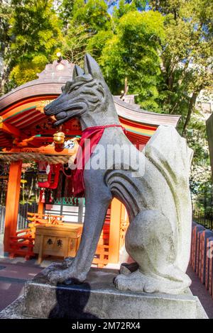 Kobe Japan Dez. 6. 2022: Statue eines Kitsune mit rotem Votivbib im Inari Ōkami im Ikuta-Schrein. Stockfoto