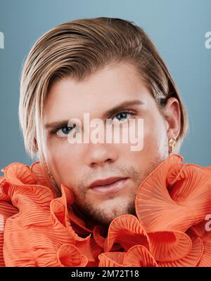 Schönheit, lgbtq und Gesicht eines Mannes mit Mode für Selbstdarstellung, nicht binärer Identität und kreativem Stil auf blauem Hintergrund im Studio. Retro, klassisch Stockfoto