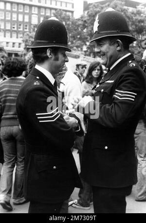 Zwei sprechende Polizisten (Bobbies) in London, England. Das Foto wurde im Sommer 1977 aufgenommen Stockfoto