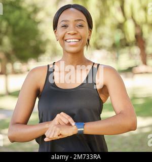 Smartwatch, Fitness oder glückliche schwarze Frau nehmen die Natur auf, um Trainingsstatistiken, Training oder Laufleistung zu überwachen. Park, Gesicht oder gesundes Mädchen Stockfoto