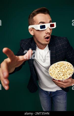 Ein Mann in 3D-Brille mit einem großen Eimer Popcorn Stockfoto