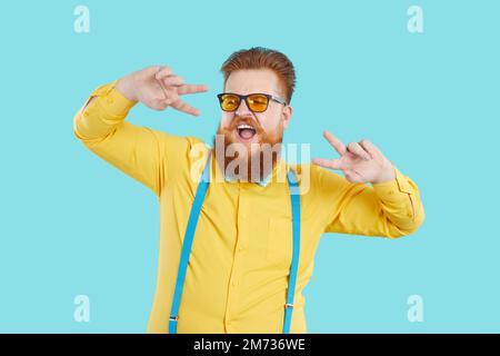 Ein witziger, bärtiger weißer Mann tanzt als Moderator oder Showman im Studio Stockfoto