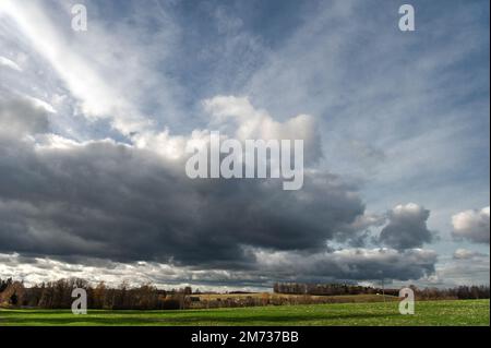 Dramatischer Himmel mit dunklen Regenwolken über der herbstlichen Landschaft Stockfoto