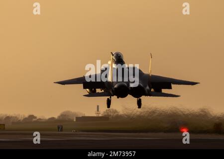 Kampfjet bei Sonnenuntergang. Modernes Militärflugzeug mit orangefarbenem Himmel, das von einer Kampfmission zurückkehrt. Stockfoto