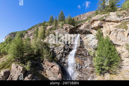 Direkter Blick auf den Wasserstrom des Lillaz Wasserfalls (Cascate di Lillaz) auf Granitfelsen mit grünen Pinien im Gran Paradiso Nationalpark Stockfoto