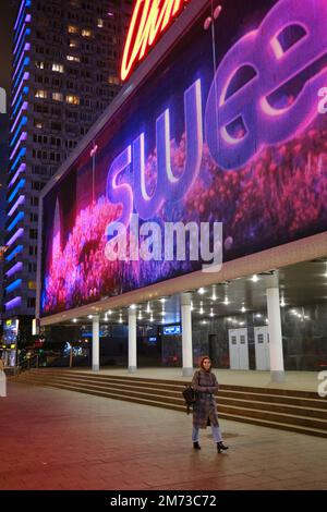 Eine Frau läuft nachts auf dem Bürgersteig auf der Novy Arbat (New Arbat) Straße. Moskau, Russland. Stockfoto