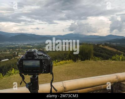 DSLR-Kamera auf einem Stativ, mit der die Landschaft am Yun Lai Aussichtspunkt in Pai, Nord-Thailand, fotografiert wird Stockfoto