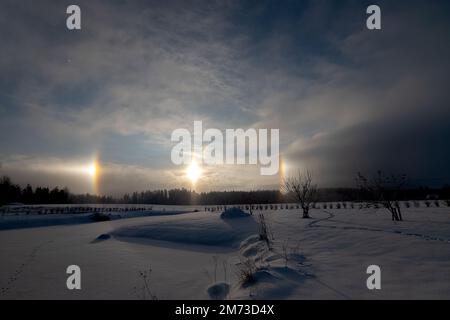 Sonnenuntergang im Winter und natürliches atmosphärisches Phänomen Halo, Parhelion, parhelia, Sundog in Lettland Stockfoto