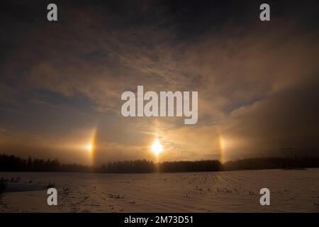 Sonnenuntergang im Winter und natürliches atmosphärisches Phänomen Halo, Parhelion, parhelia, Sundog in Lettland Stockfoto